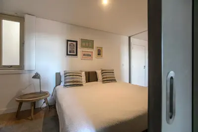 a small bedroom with a bed and a table at Modern 18th Century Flat in Porto