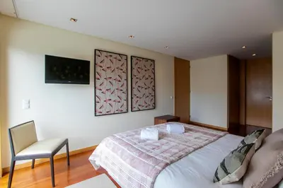 a bedroom with a bed and a chair at Comfy Luxury Apartment in Porto