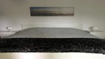 a large bed in a bedroom with two lamps at Cocooning Appartement in Porto