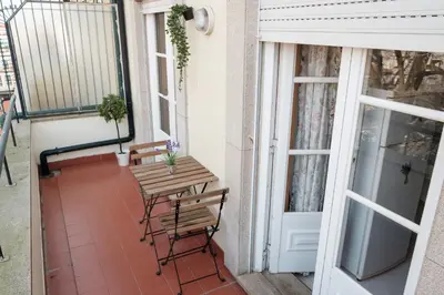 a patio with a table and chairs on a balcony at apartment with balcony in the square in Porto