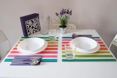 a table with plates and glasses on a colorful table cloth at apartment with balcony in the square in Porto