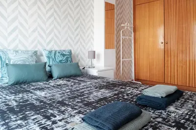a bedroom with a large bed with blue pillows at apartment with balcony in the square in Porto