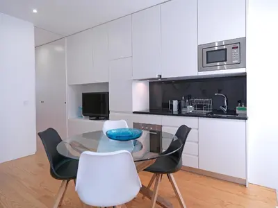 a dining room with a glass table and white chairs at FLH Porto Balcony Apartment in Porto