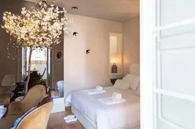 a bedroom with a white bed and two chairs at BOUTIQUE Rentals - Little Treasure Studio in Porto