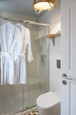 a bathroom with a shower with white towels hanged at BOUTIQUE Rentals - Little Treasure Studio in Porto