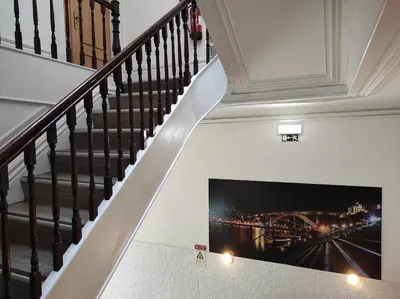 a staircase with a painting of a bridge on the wall at Lira Guest House B&B in Porto