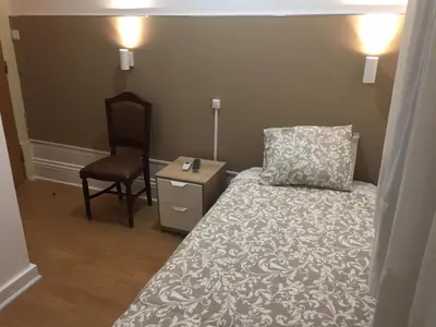 a small bedroom with a bed and a chair at Lira Guest House B&B in Porto