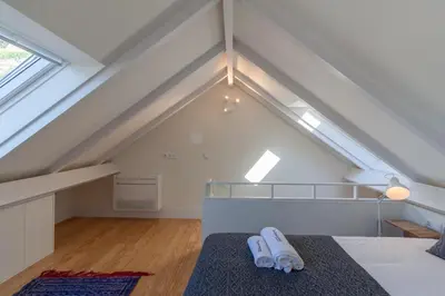 a attic bedroom with a bed and a window at FLH Douro View Luxury Duplex in Porto