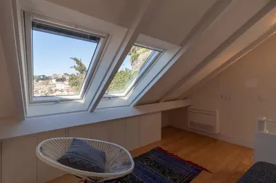 a room with two windows and a white chair at FLH Douro View Luxury Duplex in Porto