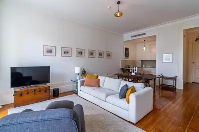 a living room with a white couch and a television at Casa do Cativo in Porto