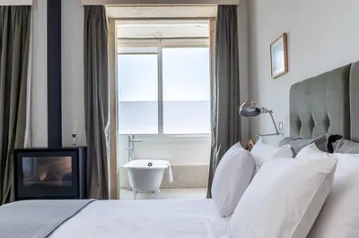 a bedroom with a bed and a bathroom with a tub at Casa do Cativo in Porto