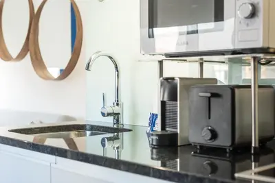 a kitchen counter with a sink and a microwave at GuestReady - Theater Apartment in Porto