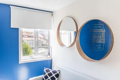 a mirror in a living room with a blue wall at GuestReady - Theater Apartment in Porto