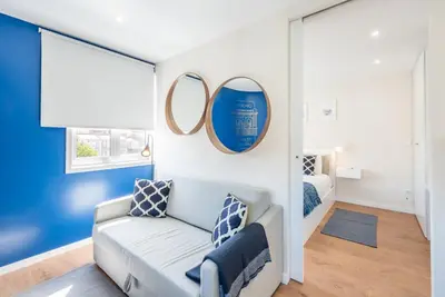 a living room with a couch and a mirror at GuestReady - Theater Apartment in Porto