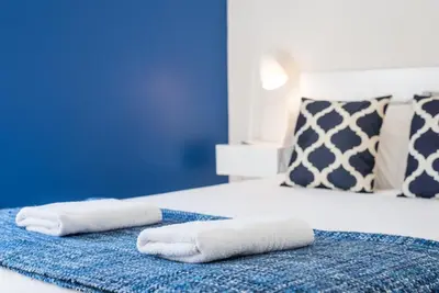 two towels on a bed in a blue room at GuestReady - Theater Apartment in Porto