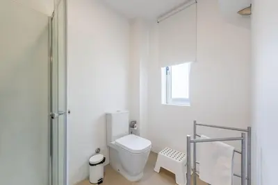 a white bathroom with a toilet and a shower at GuestReady - Theater Apartment in Porto