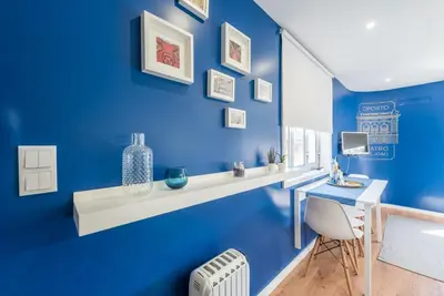 a blue room with a desk and a chair at GuestReady - Theater Apartment in Porto