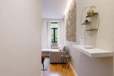 a white living room with a couch and a mirror at Oporto City View - São Lázaro in Porto