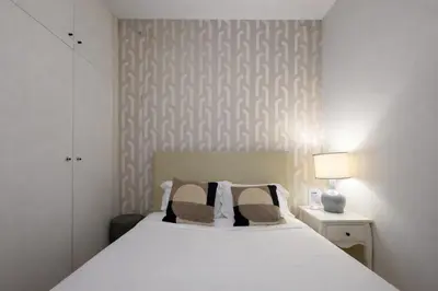 a bedroom with a white bed with two pillows at Oporto City View - São Lázaro in Porto
