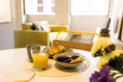 a tray with a glass of orange juice and a bowl of fruit at Studio Tomás Gonzaga in Porto