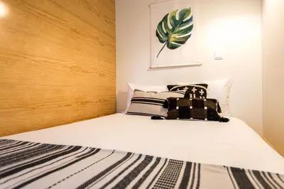 a bedroom with a large white bed with black and white pillows at Studio Tomás Gonzaga in Porto