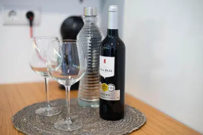 a bottle of wine and two glasses on a table at Merc Porto Bolhão Place in Porto