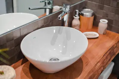a white sink on a wooden counter in a bathroom at Merc Porto Bolhão Place in Porto