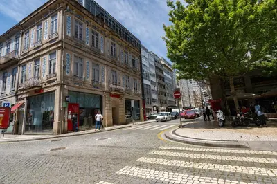 a city street with buildings and a tree and a street sign at Merc Porto Bolhão Place in Porto