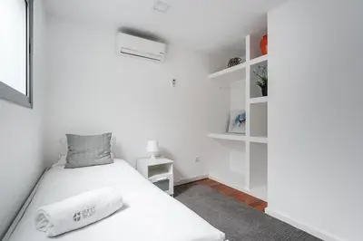 a white bedroom with a bed and shelves at GuestReady - Beautiful Plateau in Porto