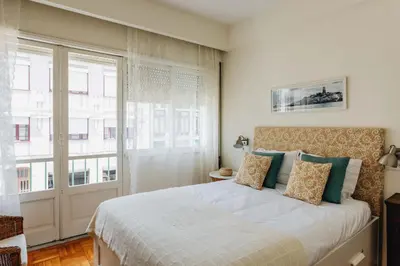 a bedroom with a bed and a large window at Cozy 1-Bedroom with Private Terrace in Palmela in Porto