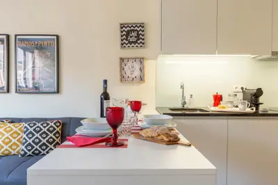 a kitchen with a table with food and wine glasses at Oporto Between Walls by the center with A/C in Porto