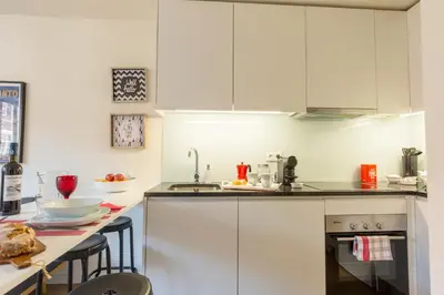 a kitchen with white cabinets and a counter top at Oporto Between Walls by the center with A/C in Porto