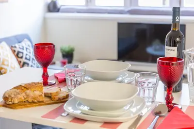 a table with plates and glasses and a bottle of wine at Oporto Between Walls by the center with A/C in Porto