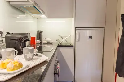 a kitchen with a plate of food and a refrigerator at Oporto Between Walls by the center with A/C in Porto