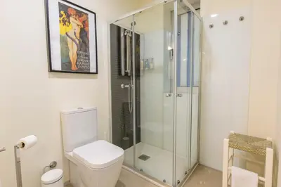 a bathroom with a toilet and a glass shower at Oporto Between Walls by the center with A/C in Porto