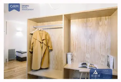 a wooden shelf with a coat hanging on it at ORM - Bainharia Apartment in Porto