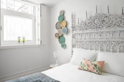 a bedroom with a large bed with a green headboard at Downtown Historic Apartments in Porto