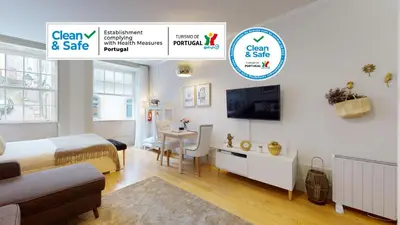 a bedroom with a bed and a desk and a tv at Oporto Golden View Vitória in Porto