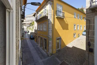 an alley with a yellow building and a street at Oporto Golden View Vitória in Porto