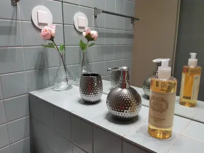 a bathroom counter with bottles and flowers in a mirror at Oporto Golden View Vitória in Porto