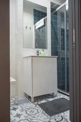a bathroom with a sink and a shower with a mirror at Suite In in Porto