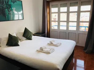 a bedroom with a white bed with towels on it at Clérigos Apartments in Porto
