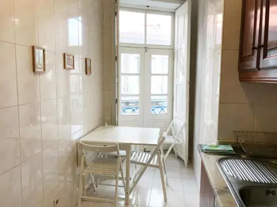a kitchen with a table and chairs and a window at Clérigos Apartments in Porto