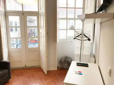 a living room with a table with a lamp and windows at Clérigos Apartments in Porto