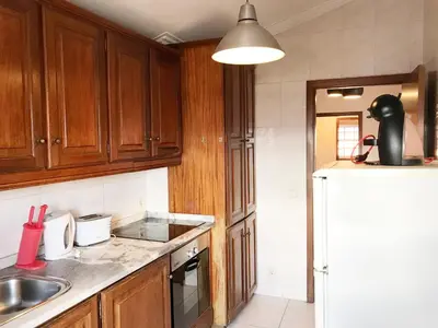 a kitchen with wooden cabinets and a sink and a counter top at Clérigos Apartments in Porto