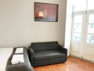 a living room with a black couch and a window at Clérigos Apartments in Porto