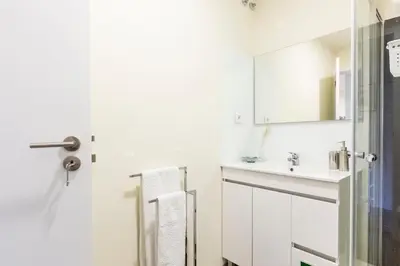 a white bathroom with a sink and a mirror at Opo Arte Apartment with terrace and A/C in Porto