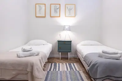 a bedroom with two beds and a table with a lamp at Vale71house in Porto