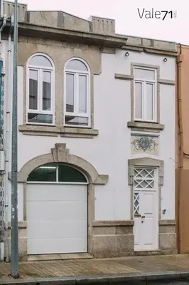 a white house with a white garage door at Vale71house in Porto