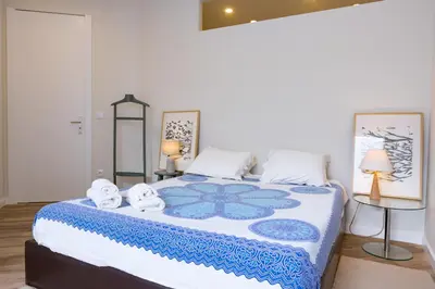 a bedroom with a large bed with towels on it at Vale71house in Porto